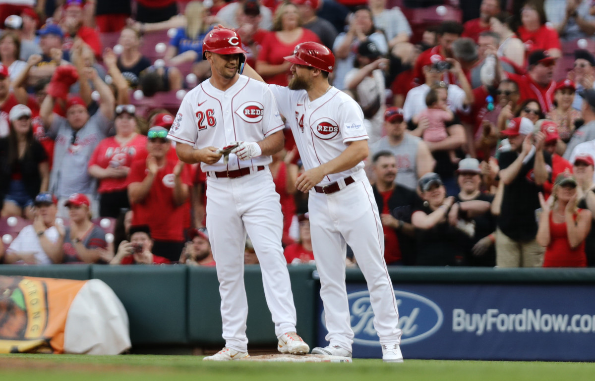Cincinnati Reds first base coach Collin Cowgill (right) reacts with pinch hitter TJ Hopkins during a game. (2023)